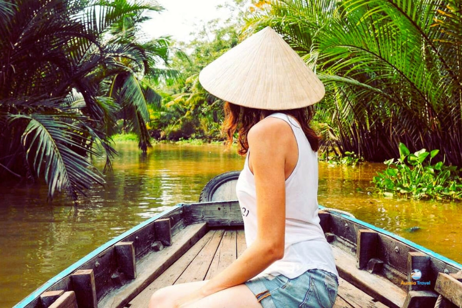 Traveler exploring Mekong Delta waterways by wooden boat – Auasia Travel